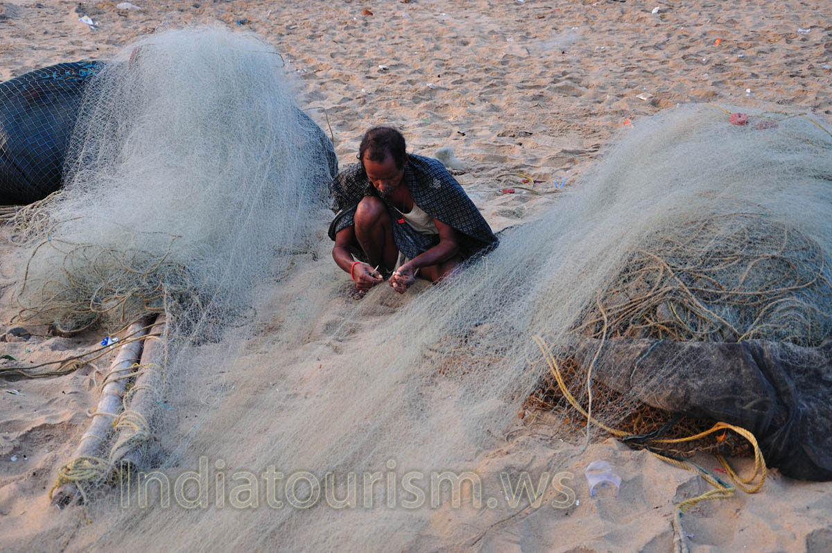 Indian fisherman is repairing fishing net