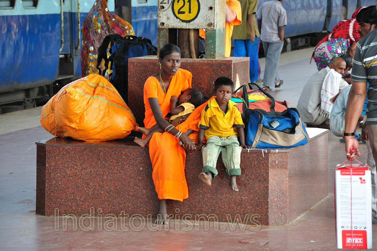 A woman breastfeeds a child at the railway station