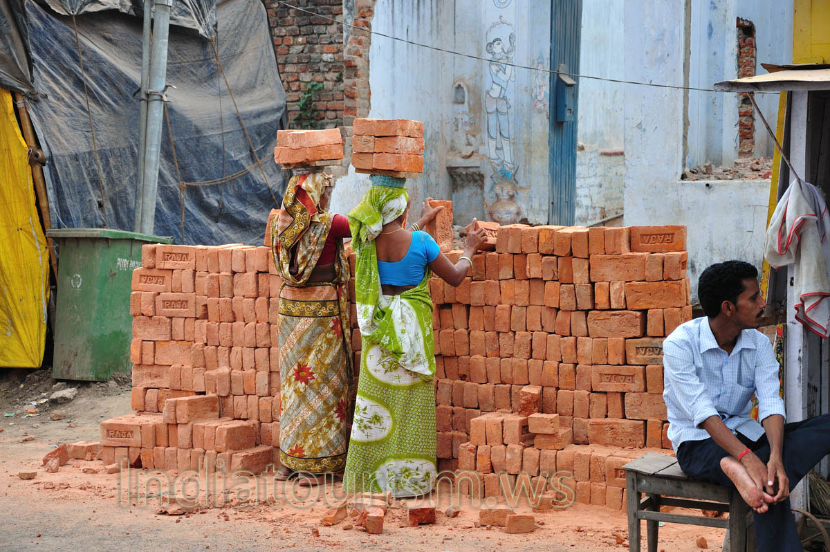 Women load bricks on their heads