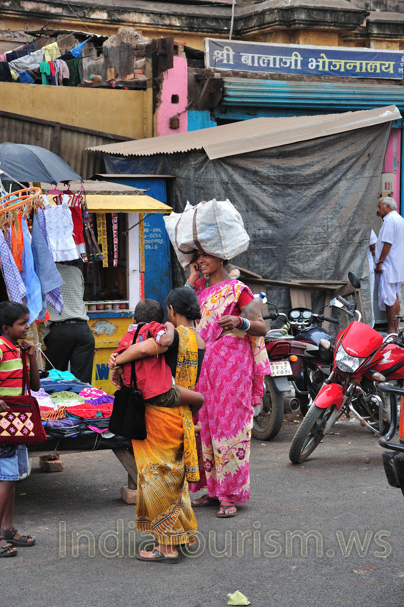 A woman is talking on a cell phone with a bag on the head