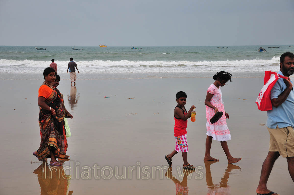 The Indian family walks on the ocean coast