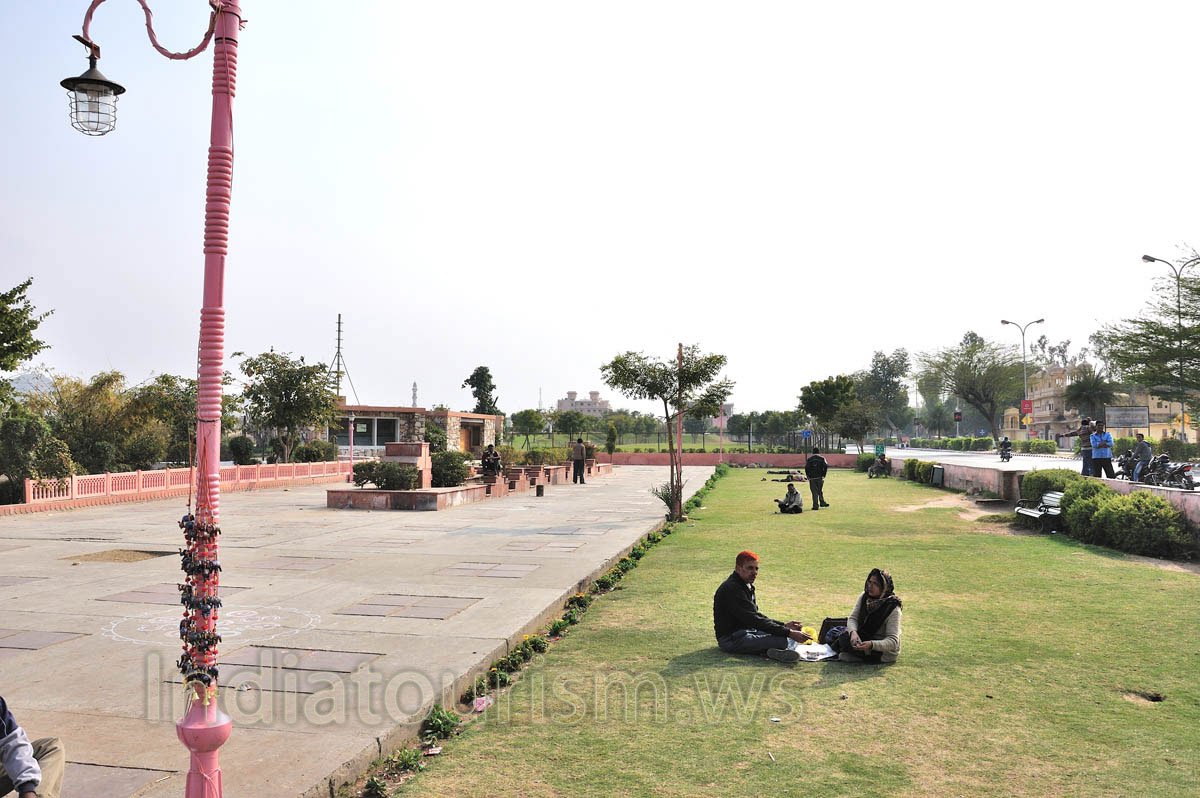 Indians like to sit on the grass of Jal Mahal seafront