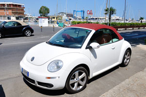 The tiny Volkswagen with number DY397MA is parked near the beach
