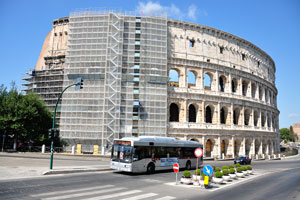 Bus 87 travels along the road near the Colosseum