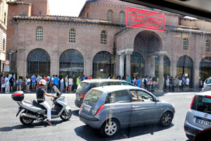 We see the long queue of tourists near the Basilica of Saint Mary in Cosmedin from the bus