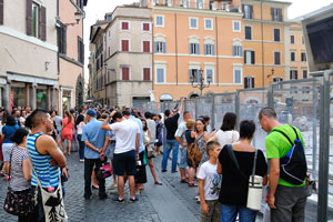 Tourists are walking near the Trevi Fountain