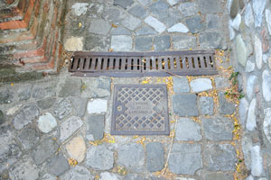 An inscription on the square metal hatch reads “Comune of Santarcangelo”