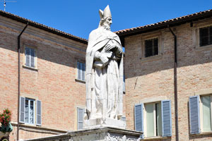 Statue of Beato Mainardo with a book under his arm in front of Urbino Cathedral