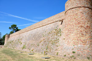 The wall of Albornoz Fortress is covered by grass