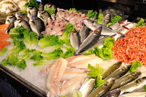 Fish is decorated by green leaves on the seafood counter