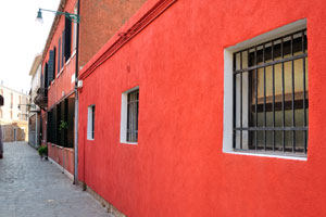 The building with the bright red wall on Murano island