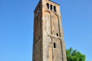 The bell tower of the church of Santa Maria e San Donato stands separately from the church building