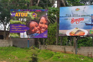 Such board advertisements are found on the roads of Cocody