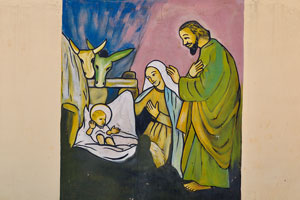 The painting of “Baby Jesus in a manger” is on the fence of the Cathedral of St. John the Baptist