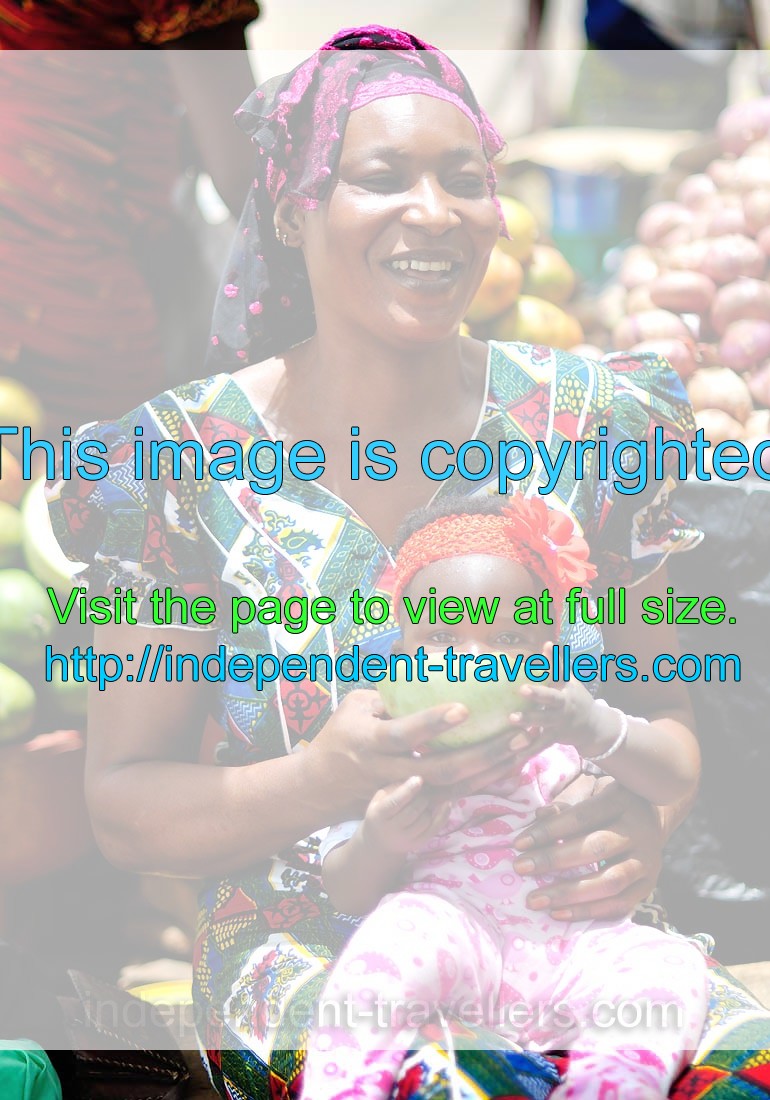 Ivorian woman is smiling while her baby is looking at me