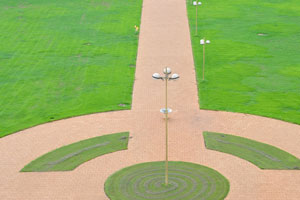 Paved paths of round shapes are amidst the lawn of Basilica of Our Lady of Peace