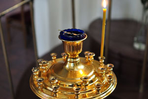 A candlestick with one candle is in the Cathedral of the Theotokos