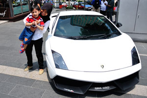 Malaysian mother with her child are posing next to the white Lamborghini car “GIMI 550”