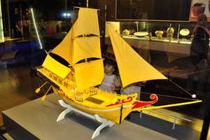 Little girl is looking with the great interest on miniature of the ship