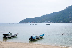 Three motor boats with outboard motors against the backdrop of the Perhentian Kecil island
