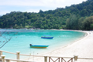 Water on the Teluk Pauh beach has a stunning emerald color