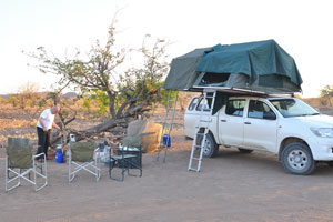 Car roof top tents are fully deployed at the camping pitch in Palm Camp