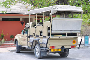 A safari vehicle “NWR” is parked at the parking lot of Halali Campground