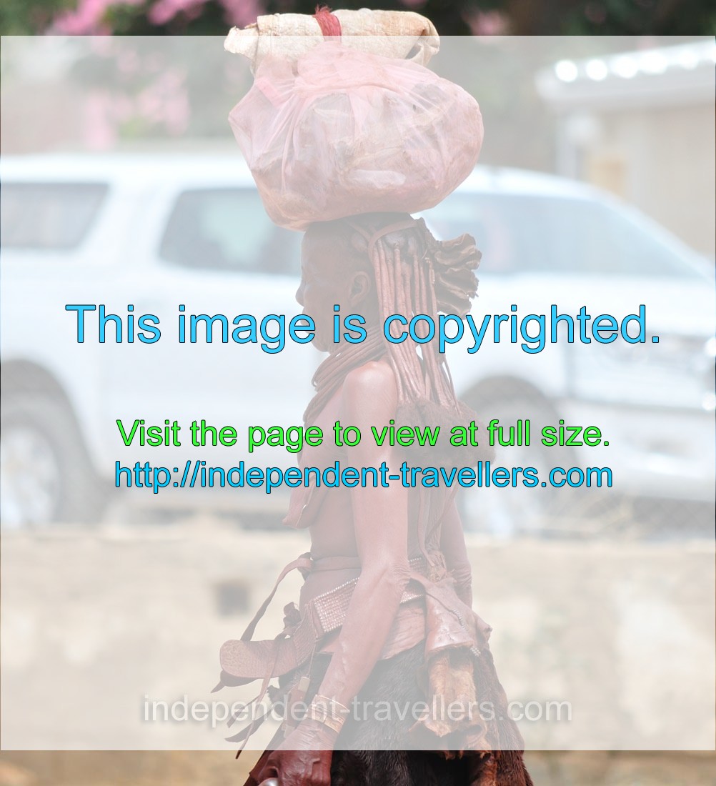 An old Herero woman carries a luggage on the head