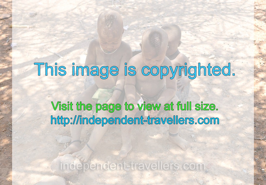 Little Himba boys look with curiosity on the sweets