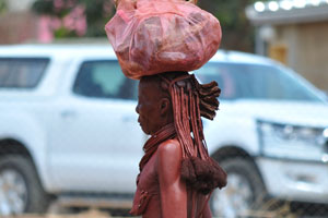 An old Herero woman carries a luggage on the head