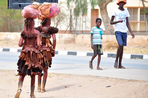 Herero women are walking with their luggage on the heads