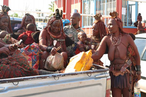 Himba women are sitting inside the truck at the entrance to the Opuwo State Hospital