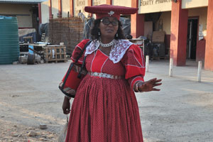 A Herero woman is posing near the Opuwo supermarket