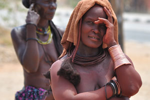 This Himba woman looks with a curiosity on the white tourists