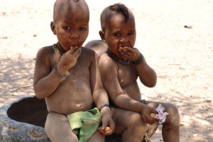 Little Himba boys are eating the sweets