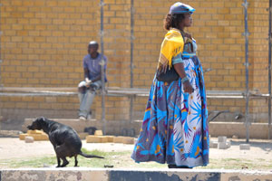 A Herero woman with earphones is on a street