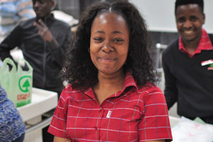 A beautiful Namibian female cashier smiles while working in Spar grocery store