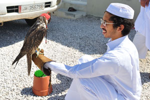 A hunter and a falcon are in the city of Madīnat ash Shamāl