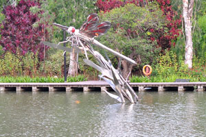 Silver dragonfly statue on the lake