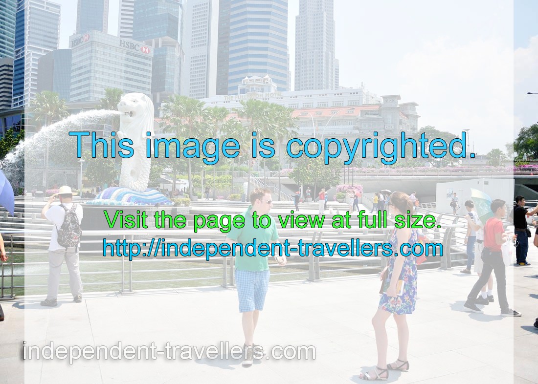 Couple of young tourists in front of the Merlion statue