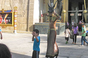 Egyptian man on spring-loaded stilts at the Revenge of the Mummy's entrance