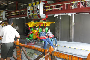 Canopy Flyer is a roller coaster attraction, here you can see two riders in the suspended car before their ride