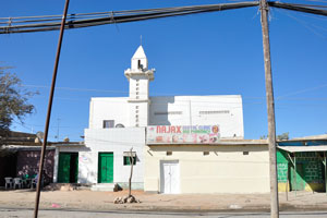 Advertisement of the Najax dental clinic and pharmacy is posted over the entrance to the mosque
