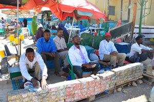 Bundles of Somaliland's own currency bills are laid out by money-changers on a street