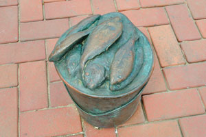 This bucket of fish belongs to the fisherman's sculpture on the square of Plaza Alonso Ojeda