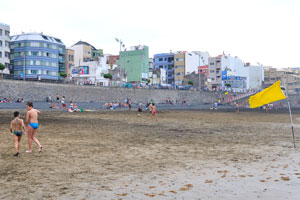 A yellow flag is on the beach of Las Canteras
