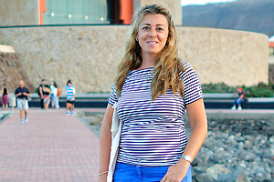 A beautiful Spanish woman with dog is on the beach of Las Canteras