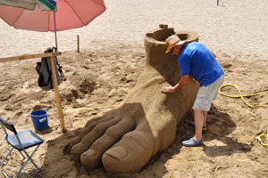 A sculptor will finish the sand sculpture of a human foot soon
