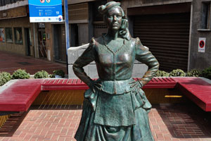 The statue of María Dolores Sánchez Ramírez is located beside the european restaurant of “Ristorante Pizzería Al Maccaroni”