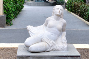 The white statue of a topless woman is in front of the Hotel Santa Catalina